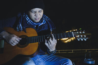 Man playing guitar at night