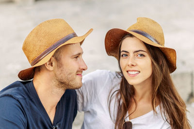 Portrait of young woman wearing hat against sky