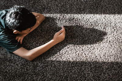 High angle view of boy laying down on road