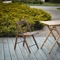 Empty chairs and table on grass