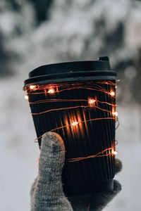 Cropped hand holding illuminated light bulb