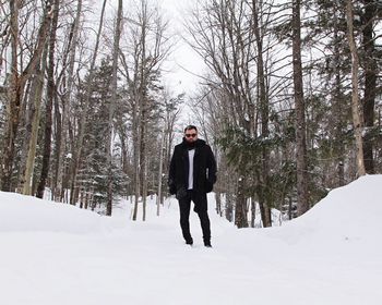 Bare trees on snow covered landscape