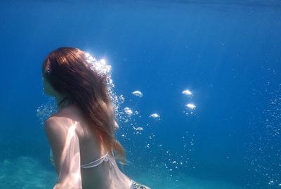 View of woman swimming in blue sea