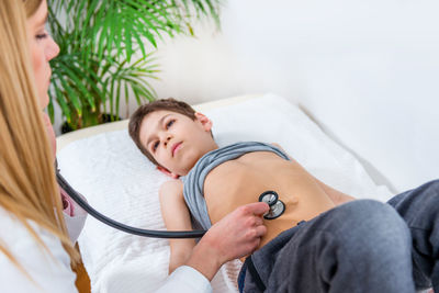 Female doctor examining boy at clinic