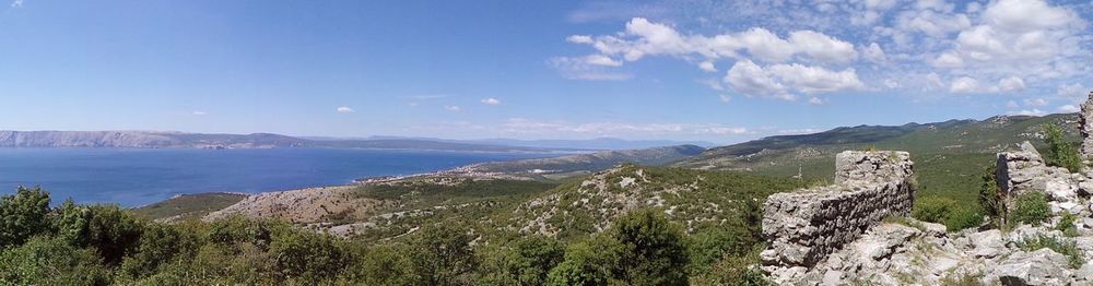 Panoramic view of sea and mountains against sky