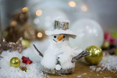 Close-up of christmas ornaments and snowman figurine on table
