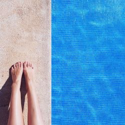 Low section of woman relaxing in swimming pool