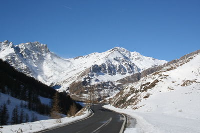 Scenic view of snowcapped mountains against clear blue sky
