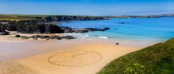 Scenic view of beach against blue sky