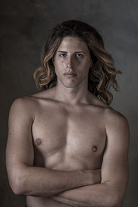 Portrait of shirtless man with long hair