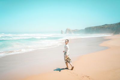 Full length of woman on beach against sky