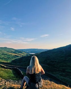 Rear view of woman looking at landscape against sky