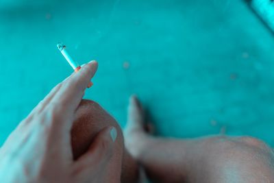 Close-up of woman smoking cigarette in swimming pool