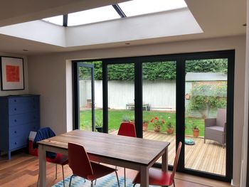 Empty chairs and table against window in building