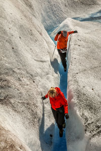 People climbing on snow covered mountain