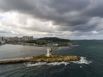 Scenic view of sea by buildings against sky