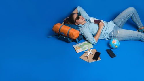 Digital composite image of child lying down against blue background