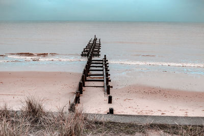 Lifeguard hut on beach against sky