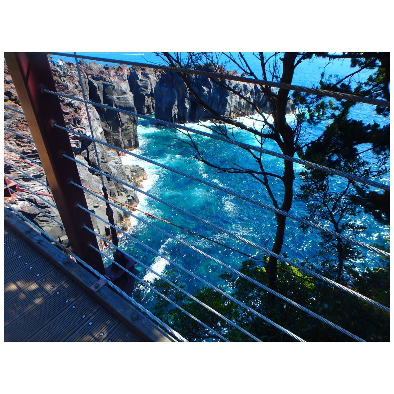 transfer print, auto post production filter, built structure, architecture, sky, low angle view, day, water, sunlight, blue, clear sky, nature, railing, outdoors, no people, high angle view, sea, tilt, tree, building exterior