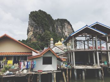 Houses by mountains against sky