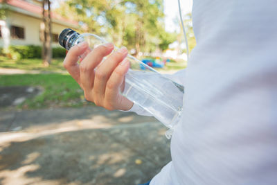 Close-up of hand holding glass bottle