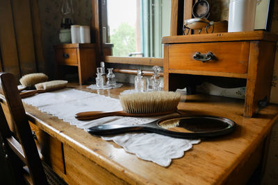 Close-up of mirror and hairbrush on dressing table at home