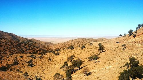 Scenic view of desert against clear blue sky