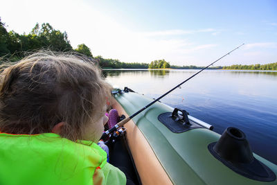 Rear view of woman fishing in lake