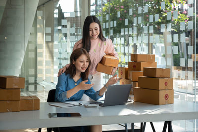 Portrait of young woman using digital tablet while sitting on table