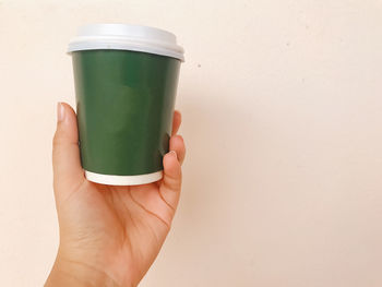 Cropped image of hand holding coffee cup