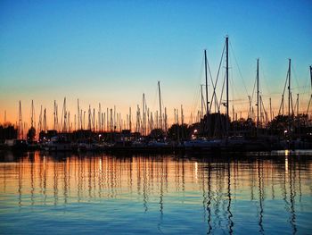 Silhouette of boats in harbor at sunset