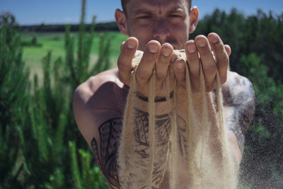 Close-up portrait of man holding sand