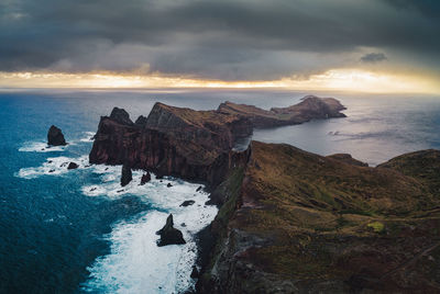 Rain and sunrise above the rugged coastline.