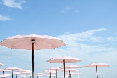 Low angle view of parasol against blue sky