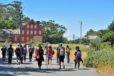 People walking on road in city against clear sky