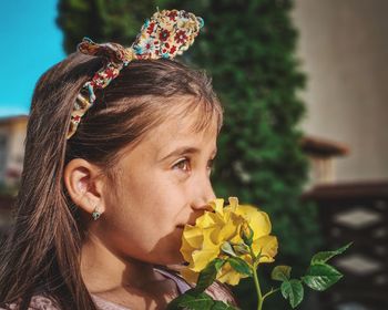 Close-up of young woman with yellow flower 