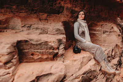 Portrait of woman sitting on rock