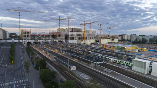 Aerial view of train in city against cloudy sky