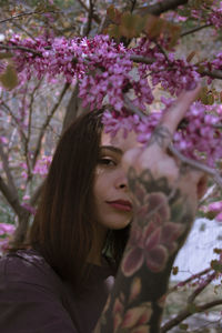 Portrait of woman with pink flower tree