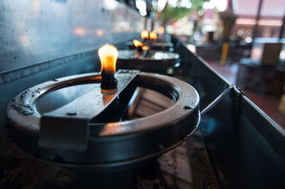 Close-up of lit tea light candles in temple