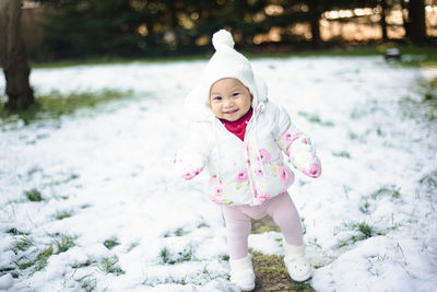 Portrait of cute baby girl standing on snow