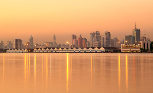 Illuminated buildings against sky during sunset