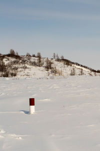 Snow covered field against sky