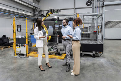 Young businessman discussing with colleagues in factory