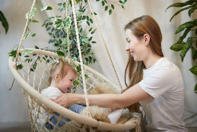 Side view of young woman sitting in hammock