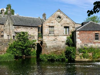 River by old building against sky