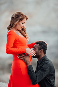 Side view of young couple standing outdoors