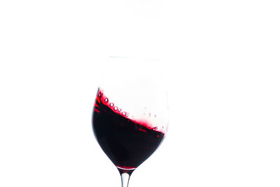 Red wine glass against white background