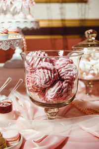 Pink marshmallows in a transparent jar, sprinkled with powdered sugar