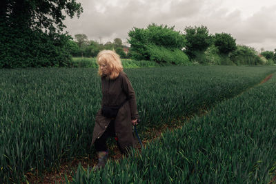 Rear view of woman walking on grassy field